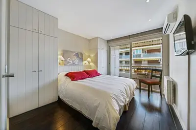 a bedroom with a large bed and a television at REF 1319 - Cannes Center - Apartment for rent in Cannes