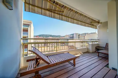 a balcony with a bench on a wooden deck at REF 1319 - Cannes Center - Apartment for rent in Cannes