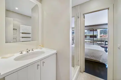 a white bathroom with a sink and a mirror at REF 1319 - Cannes Center - Apartment for rent in Cannes