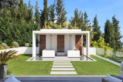 a garden with two white chairs under a gazebo at REF 1960 - Cannes - Sea view villa for rent in Cannes