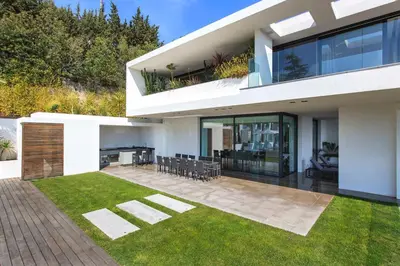 a large white house with a patio and grass at REF 1960 - Cannes - Sea view villa for rent in Cannes
