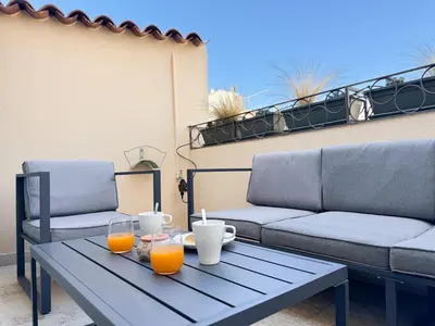 a table with two chairs and orange juice on a patio at 9A - APARTMENT FACING PORT & Town Hall in Cannes