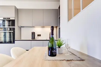 a bottle of wine sitting on a table in a kitchen at 9A - APARTMENT FACING PORT & Town Hall in Cannes