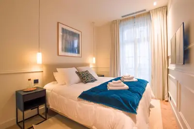 a bedroom with a large bed with a window at 12B - APARTMENT FACING PORT & Town Hall in Cannes