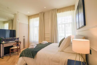 a bedroom with a bed with a desk and a television at 12B - APARTMENT FACING PORT & Town Hall in Cannes