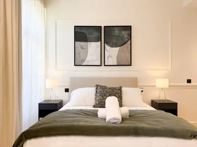 a bedroom with a bed with three pictures on the wall at 12B - APARTMENT FACING PORT & Town Hall in Cannes