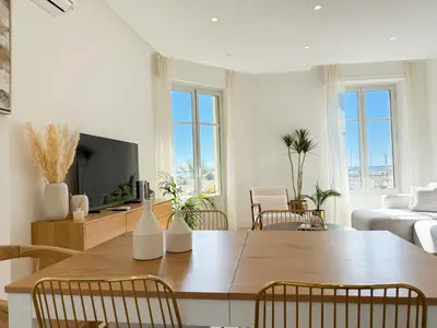 a living room with a wooden table and chairs at 4A - APARTMENT FACING PORT & Town Hall in Cannes