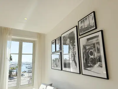 a group of framed pictures on a wall in a living room at 4A - APARTMENT FACING PORT & Town Hall in Cannes