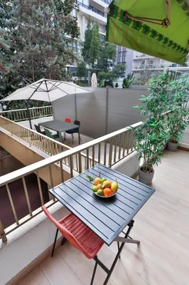 a living room with a couch and a kitchen at Spacieux T2 avec grande terrasse à 200m de la plage in Cannes
