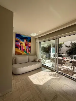 a living room with a couch and a painting on the wall at Palm Beach front de mer in Cannes