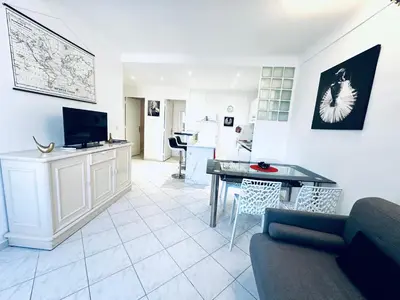a living room with a couch and a table at Grand appartement centre piéton Cannes in Cannes