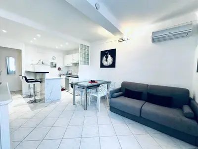 a living room with a couch and a table at Grand appartement centre piéton Cannes in Cannes