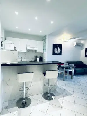 a kitchen with a counter and two bar stools at Grand appartement centre piéton Cannes in Cannes