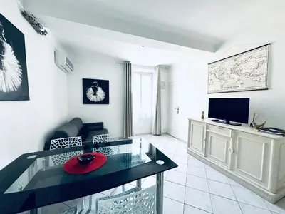 a living room with a glass table and a tv at Grand appartement centre piéton Cannes in Cannes
