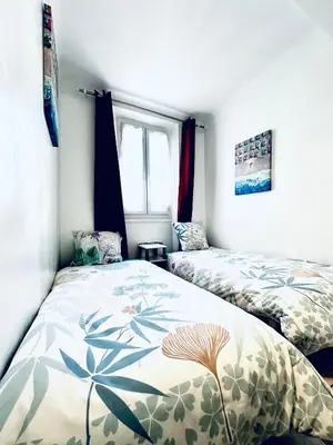 a bedroom with two beds and a window at Grand appartement centre piéton Cannes in Cannes