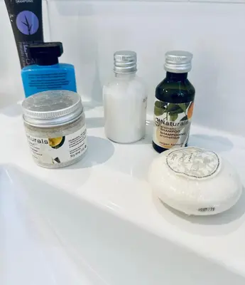 a refrigerator shelf with bottles of essential oils and a container of soap at Grand appartement centre piéton Cannes in Cannes