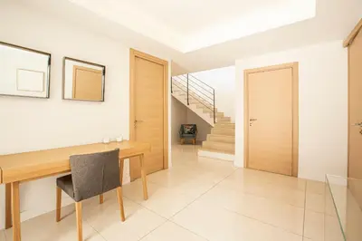 a dining room with a wooden table and a staircase at REF 2152 - Le Cannet - Sea view villa for rent in Le Cannet