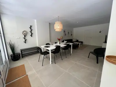 a dining room and living room with a table and chairs at Splendide maison Solstice in Cannes