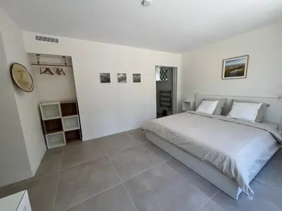 a white bedroom with a bed and a tiled floor at Splendide maison Solstice in Cannes