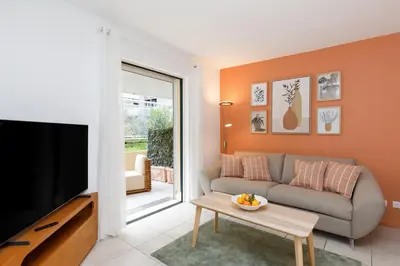 a living room with a couch and a tv at Côté Croisette LUXE - 2BdR 2 bthR 2 toilets -Terrace, AC, parking & lift in Cannes