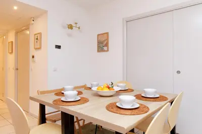 a dining room with a wooden table with chairs at Côté Croisette LUXE - 2BdR 2 bthR 2 toilets -Terrace, AC, parking & lift in Cannes