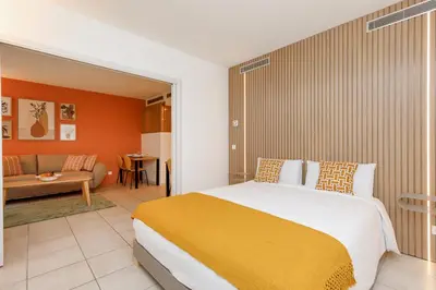 a bedroom with a large bed and a living room at Côté Croisette LUXE - 2BdR 2 bthR 2 toilets -Terrace, AC, parking & lift in Cannes