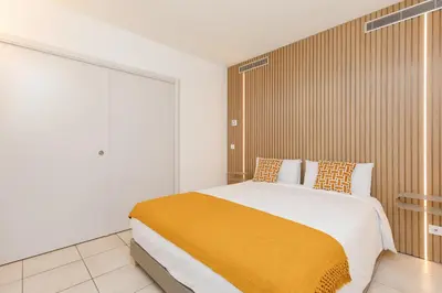a bedroom with a large bed with a yellow blanket at Côté Croisette LUXE - 2BdR 2 bthR 2 toilets -Terrace, AC, parking & lift in Cannes