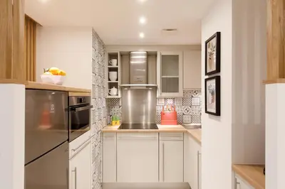 a kitchen with white cabinets and stainless steel appliances at Côté Croisette LUXE - 2BdR 2 bthR 2 toilets -Terrace, AC, parking & lift in Cannes