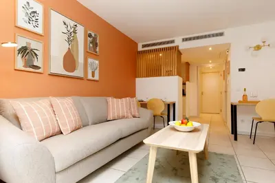 a living room with a couch and a table at Côté Croisette LUXE - 2BdR 2 bthR 2 toilets -Terrace, AC, parking & lift in Cannes