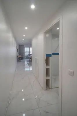 a hallway with white walls and a glass door at FRGK Victoria 4 Central Cannes 1BR Terrace, AC & Ultra-Fast Wi-Fi in Cannes