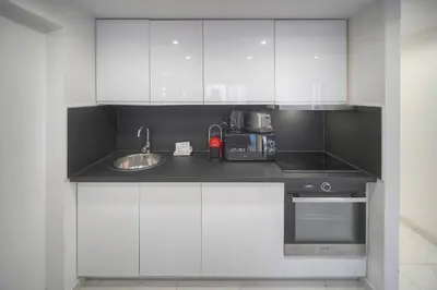 a white kitchen with a sink and a microwave at FRGK Victoria 4 Central Cannes 1BR Terrace, AC & Ultra-Fast Wi-Fi in Cannes
