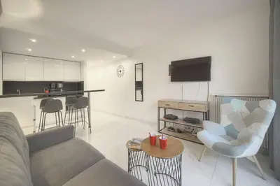 a living room with a couch and a tv and a kitchen at FRGK Victoria 4 Central Cannes 1BR Terrace, AC & Ultra-Fast Wi-Fi in Cannes
