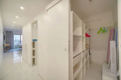 a hallway with white walls and white shelves at FRGK Victoria 4 Central Cannes 1BR Terrace, AC & Ultra-Fast Wi-Fi in Cannes
