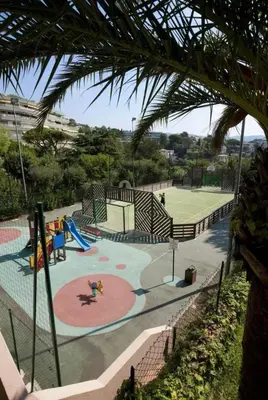 a playground with a slide and a tennis court at Appartement Vue Mer avec Piscine - Cannes in Cannes