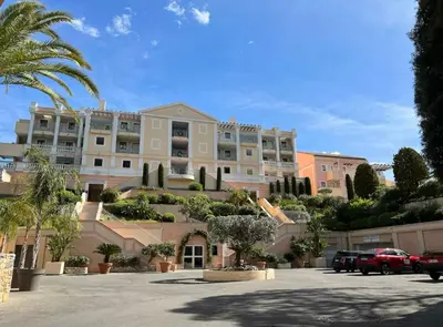 a large building with palm trees in a parking lot at Appartement Vue Mer avec Piscine - Cannes in Cannes