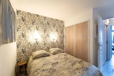 a bedroom with a bed with a patterned wall at Appartement Vue Mer avec Piscine - Cannes in Cannes