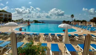 a large swimming pool with chairs and umbrellas at Appartement Vue Mer avec Piscine - Cannes in Cannes
