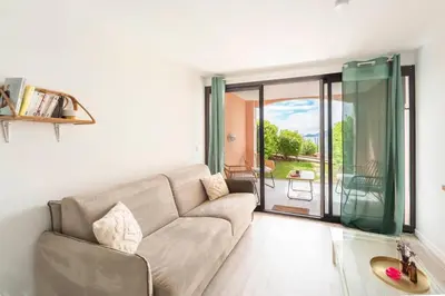 a living room with a couch and a sliding glass door at Appartement Vue Mer avec Piscine - Cannes in Cannes