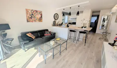 a living room with a black couch and a kitchen at 