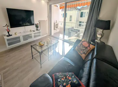 a living room with a black leather couch and a table at 