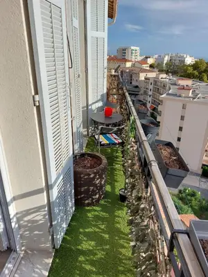 a balcony with green grass and a table on it at Stanislas sea view in Cannes