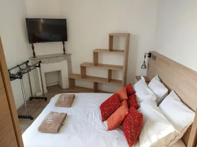 a bedroom with a bed with red pillows and a television at Stanislas sea view in Cannes