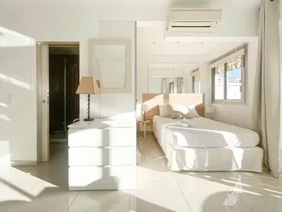 a white bedroom with a bed and a mirror at Le ROUAZE studio - proche Carlton et Martinez - idéal congrès - Wifi Clim in Cannes