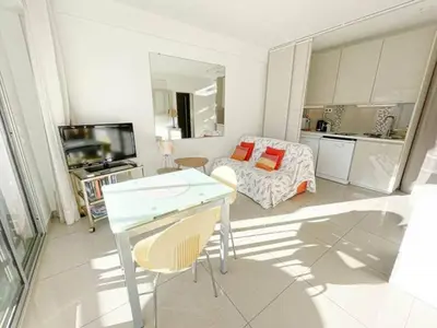 a living room with a table and a couch at Le ROUAZE studio - proche Carlton et Martinez - idéal congrès - Wifi Clim in Cannes
