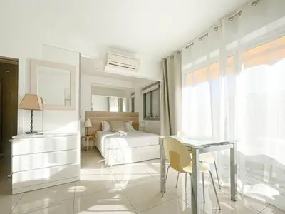 a bedroom with a bed and a glass table at Le ROUAZE studio - proche Carlton et Martinez - idéal congrès - Wifi Clim in Cannes