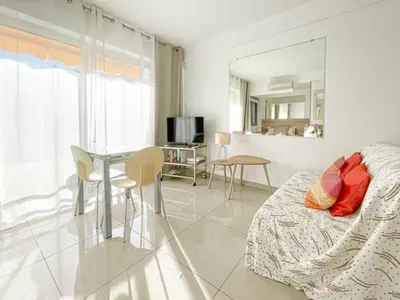 a bedroom with a bed and a table with chairs at Le ROUAZE studio - proche Carlton et Martinez - idéal congrès - Wifi Clim in Cannes