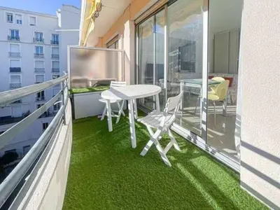 a balcony with green flooring and a table and chairs at Le ROUAZE studio - proche Carlton et Martinez - idéal congrès - Wifi Clim in Cannes
