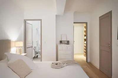 a white bedroom with a bed and a bathroom at Cannes Center, Nice 110m2, 3BR & 3BTH, Terrace in Cannes