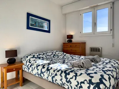a bedroom with a bed and a dresser and window at Vogue By SCLS Locations in Cannes