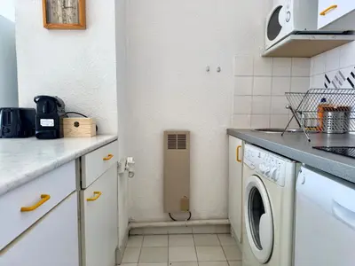 a small kitchen with a washing machine in the corner at Vogue By SCLS Locations in Cannes